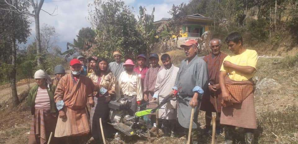 Group of Bhutanese farmers with HAoB representatives working together in the field, promoting sustainable agriculture and community farming.