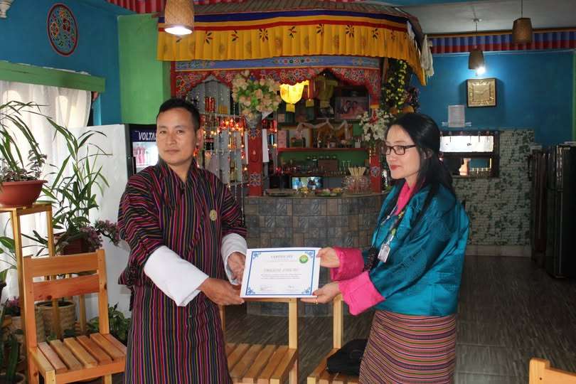 Mrs. Tharpa Lhamo receives a Certificate of Appreciation and mobile data plan for her outstanding support in goods distribution.